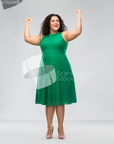 Image of happy woman in green dress showing women power