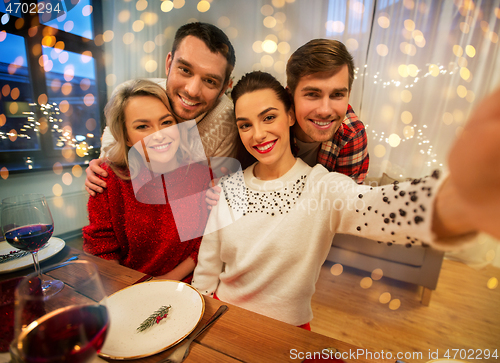 Image of friends taking selfie at christmas dinner