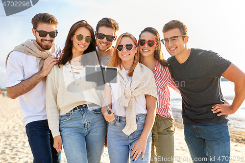 Image of happy friends taking selfie on summer beach