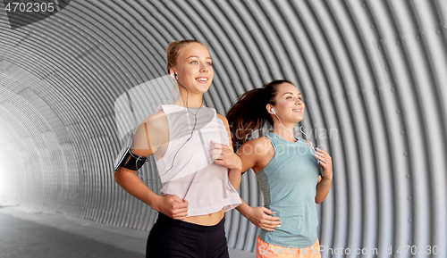 Image of young women with earphones and smartphones running