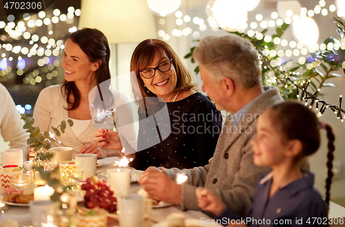 Image of family with sparklers having tea party at home