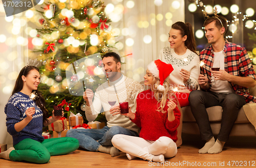 Image of friends with sparklers celebrating christmas