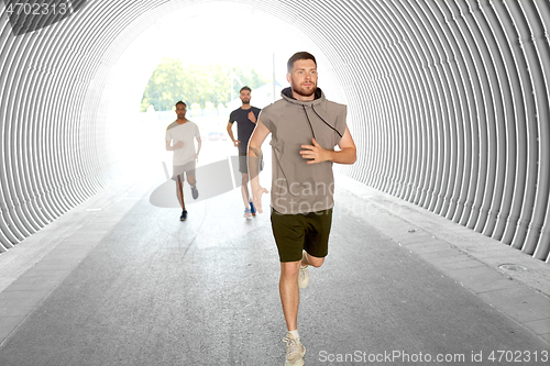 Image of young men or male friends running outdoors