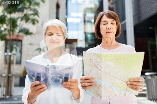 Image of senior women with city guide and map on street