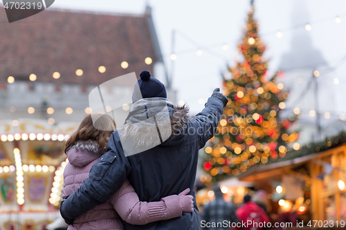 Image of happy senior couple hugging at christmas market