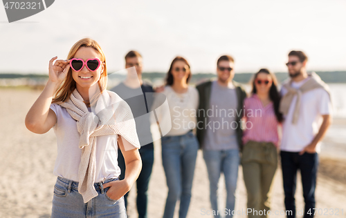 Image of happy woman with friends on beach in summer