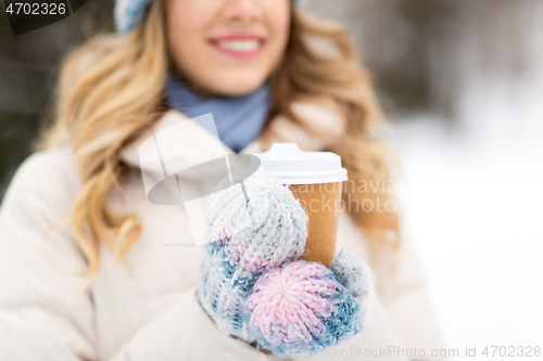 Image of happy woman drinking coffee outdoors in winter