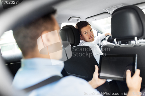 Image of male car driver and passenger with tablet pc