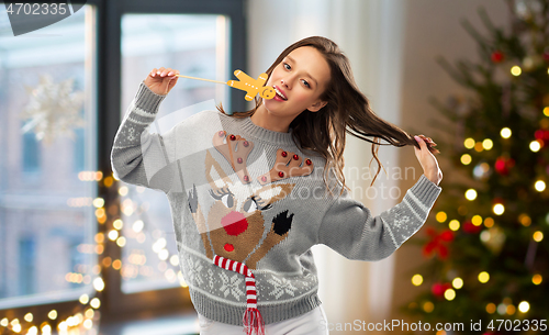 Image of woman in christmas sweater with reindeer pattern