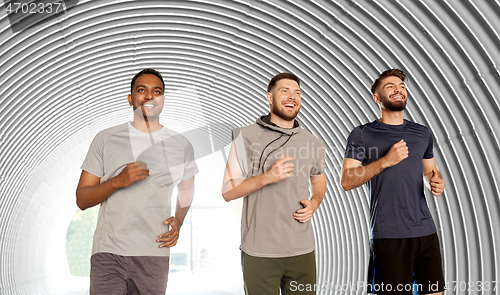 Image of young men or male friends running in tunnel