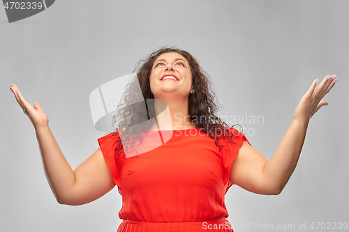 Image of happy smiling woman in red dress looking up