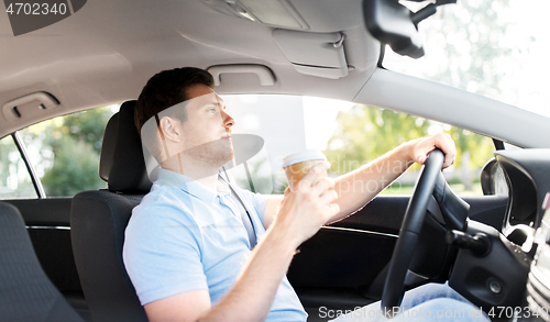 Image of man or driver with takeaway coffee cup driving car