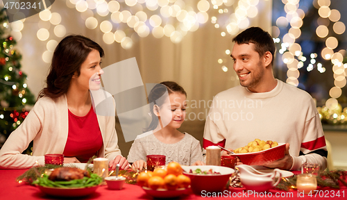 Image of happy family having christmas dinner at home