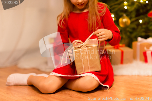 Image of close up of girl with christmas gift at home