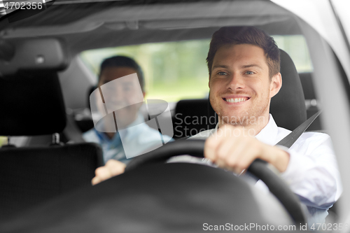 Image of male taxi driver driving car with passenger