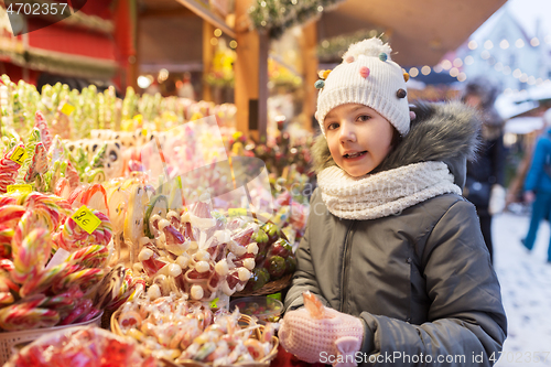 Image of girl with lollipop at christmas market candy shop