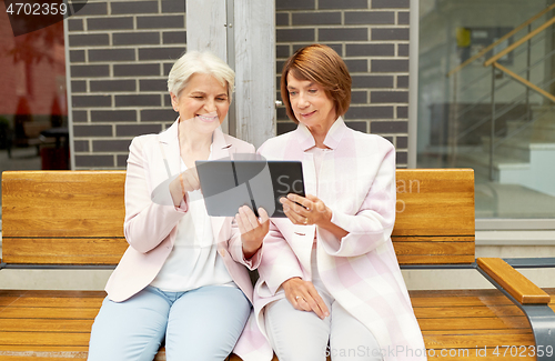 Image of senior women with tablet computer in city