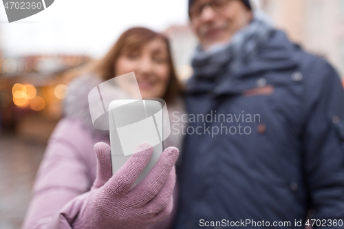 Image of couple taking selfie by smartphone on christmas