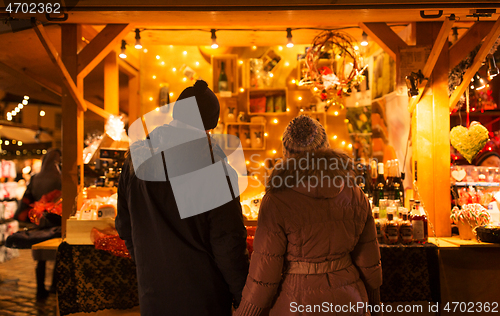 Image of happy senior couple hugging at christmas market