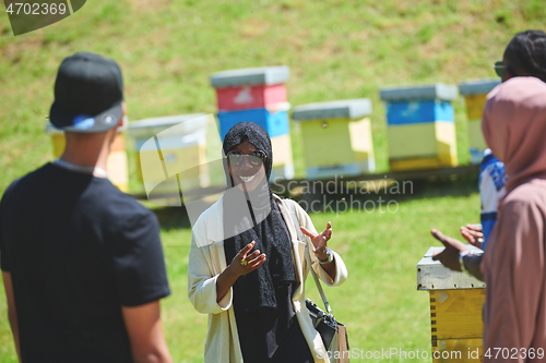 Image of woman giving presentation to group of business investors on local honey production farm