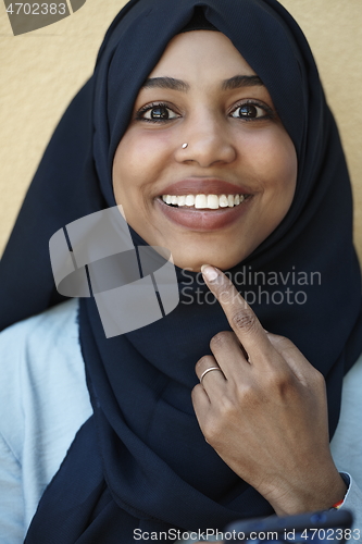 Image of african woman using smartphone wearing traditional islamic clothes