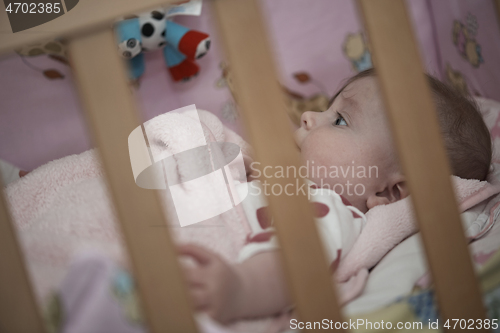 Image of cute little baby playing with hands and smiling