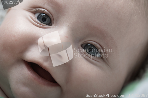 Image of cute little baby playing with hands and smiling