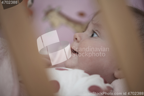 Image of cute little baby playing with hands and smiling