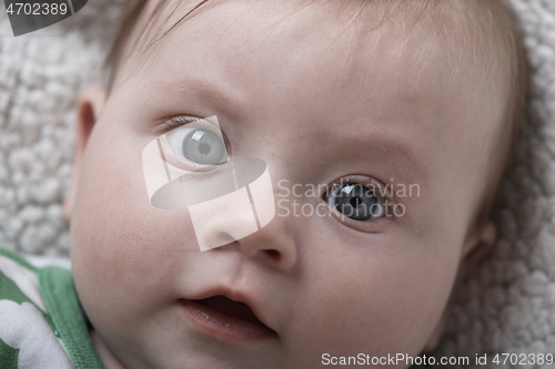 Image of cute little baby playing with hands and smiling