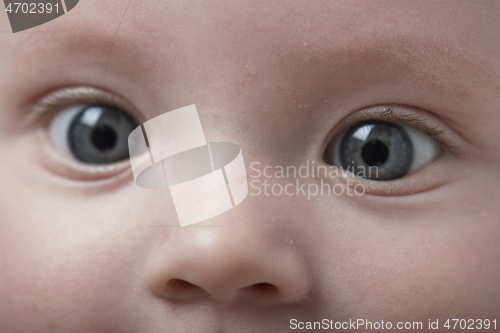 Image of cute little baby playing with hands and smiling