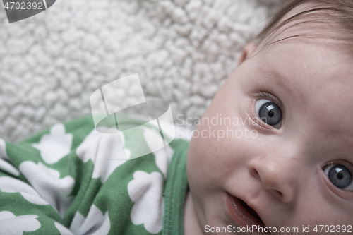 Image of cute little baby playing with hands and smiling