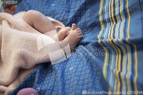 Image of cute little baby playing with hands and smiling