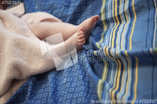 Image of cute little baby playing with hands and smiling