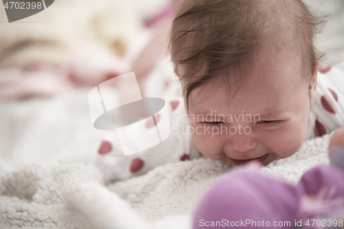 Image of cute little baby playing with hands and smiling