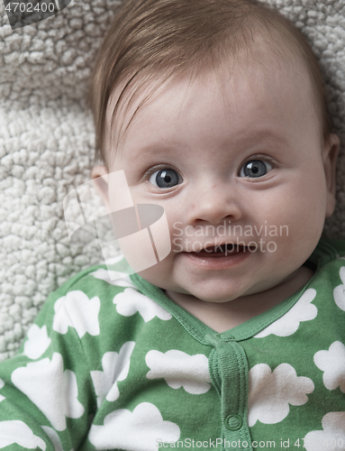 Image of cute little baby playing with hands and smiling