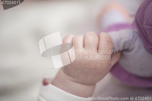 Image of cute little baby playing with hands and smiling