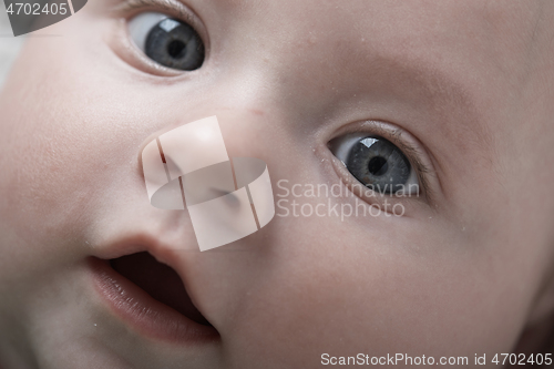 Image of cute little baby playing with hands and smiling