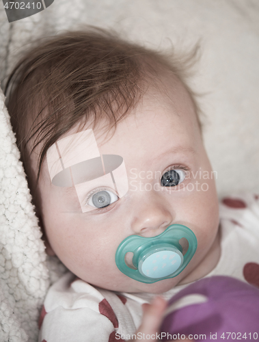 Image of cute little baby playing with hands and smiling