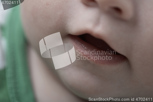 Image of cute little baby playing with hands and smiling