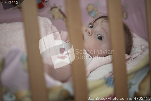 Image of cute little baby playing with hands and smiling