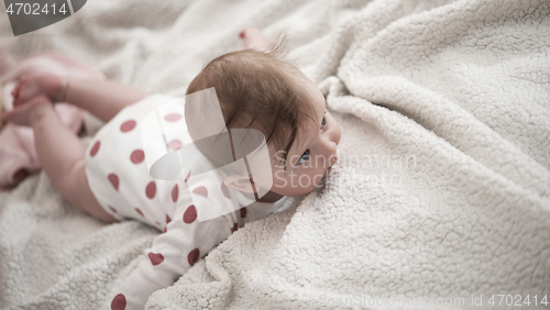 Image of cute little baby playing with hands and smiling