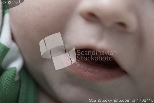 Image of cute little baby playing with hands and smiling