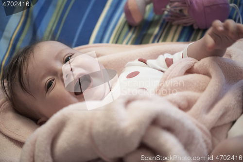 Image of cute little baby playing with hands and smiling