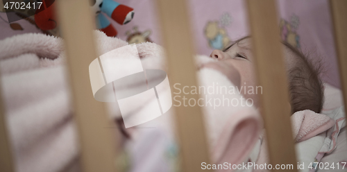 Image of cute little baby playing with hands and smiling