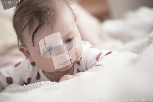 Image of cute little baby playing with hands and smiling