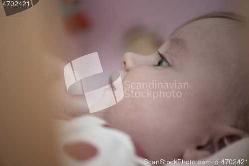 Image of cute little baby playing with hands and smiling