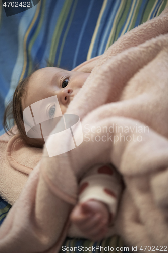 Image of cute little baby playing with hands and smiling