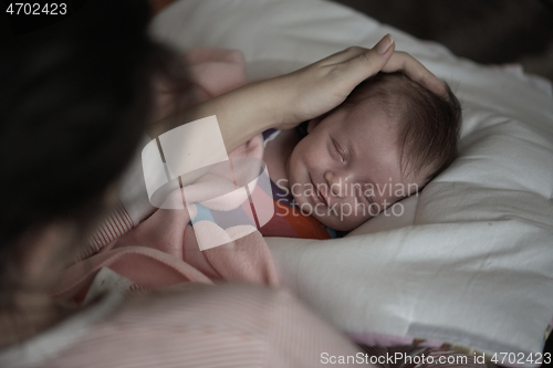 Image of new born baby sleeping and in dreams smillling