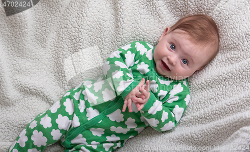 Image of cute little baby playing with hands and smiling