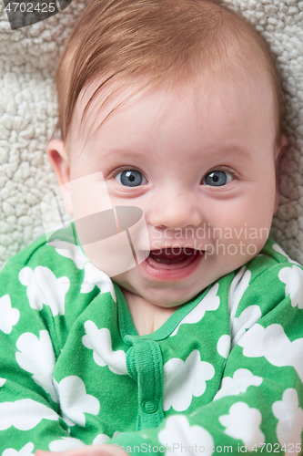 Image of cute little baby playing with hands and smiling